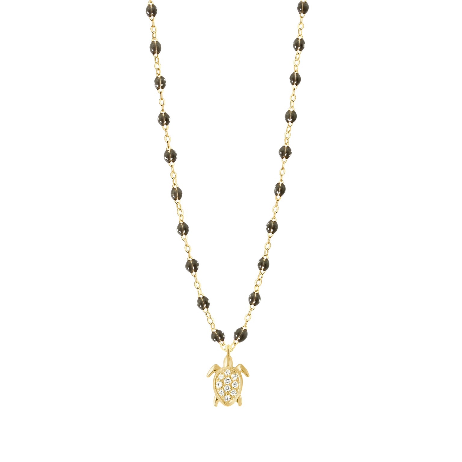 A gold chain necklace featuring small dark beads and a gold sea turtle pendant adorned with clear stones, shown against a plain white background.